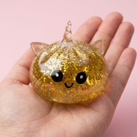 Kultainen Yksisarvinen Dumpling Squishy Glitter kädessä — kokovertailu