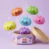 Squishy Dumpling Mystery Happy Faces -yllätyspakkaus puristettuna kädessä