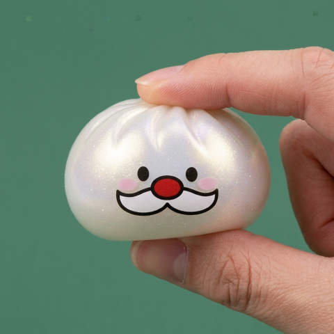 Dumpling Squishy Mystery Joulupukin Viikset puristettuna kädessä