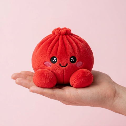 Dumpling Squishy Rubiininpunainen Pehmolelu kädessä — kokovertailu